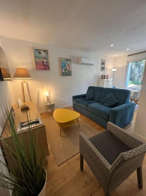 un salon avec un canapé bleu et une table dans l'établissement Le Plein Sud, à Bandol