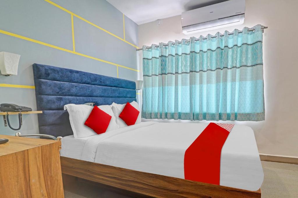 a bedroom with a bed with red and blue curtains at OYO Flagship Luxury Rooms in Hyderabad