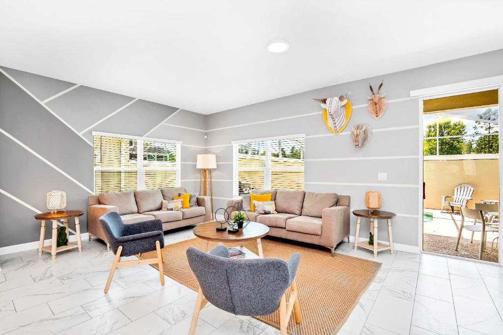 uma sala de estar com sofás e cadeiras e uma mesa em Stunning 5BR Home - Family Resort - Private Pool and BBQ! em Kissimmee