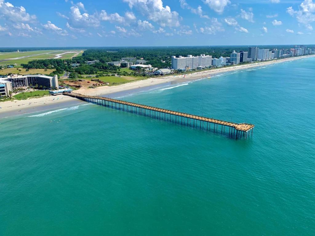 an aerial view of a pier on a beach at The Ellie Beach Resort Myrtle Beach, Tapestry By Hilton in Myrtle Beach