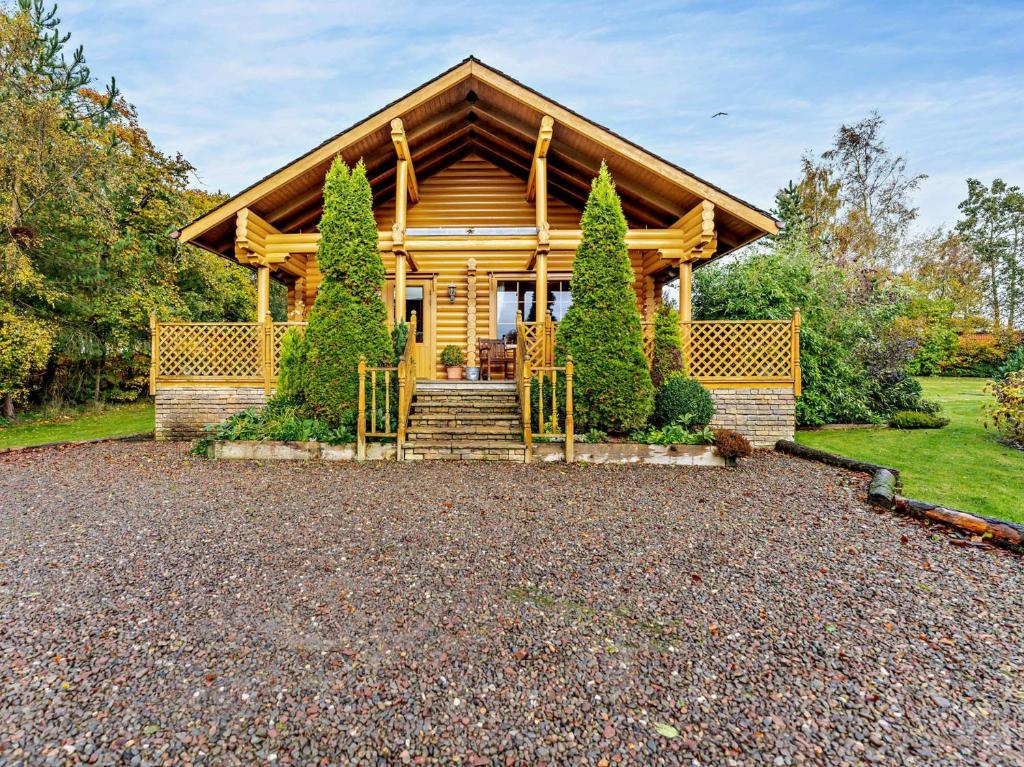 a log cabin with a porch and stairs to it at 3 Bed in Peebles LK15M in Walston