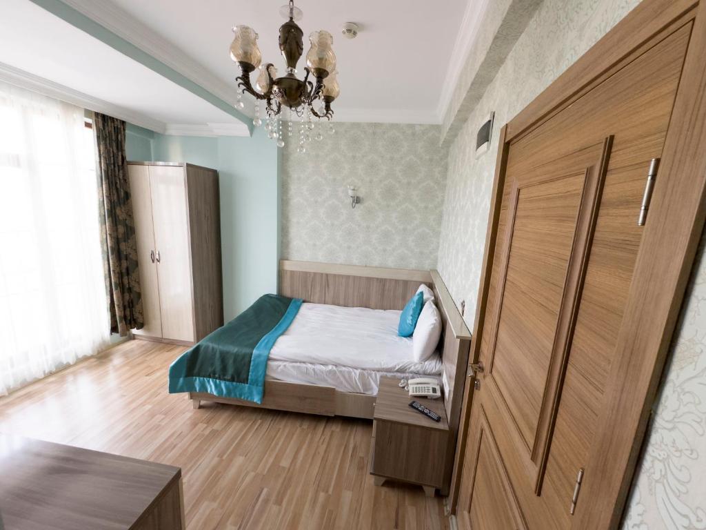 a bedroom with a bed and a large wooden door at Kars Center Hotel in Kars