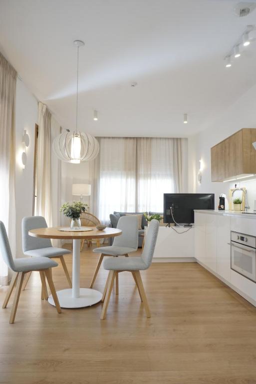 a kitchen and dining room with a table and chairs at Apartamentos La Casa El Palo in El Rompido