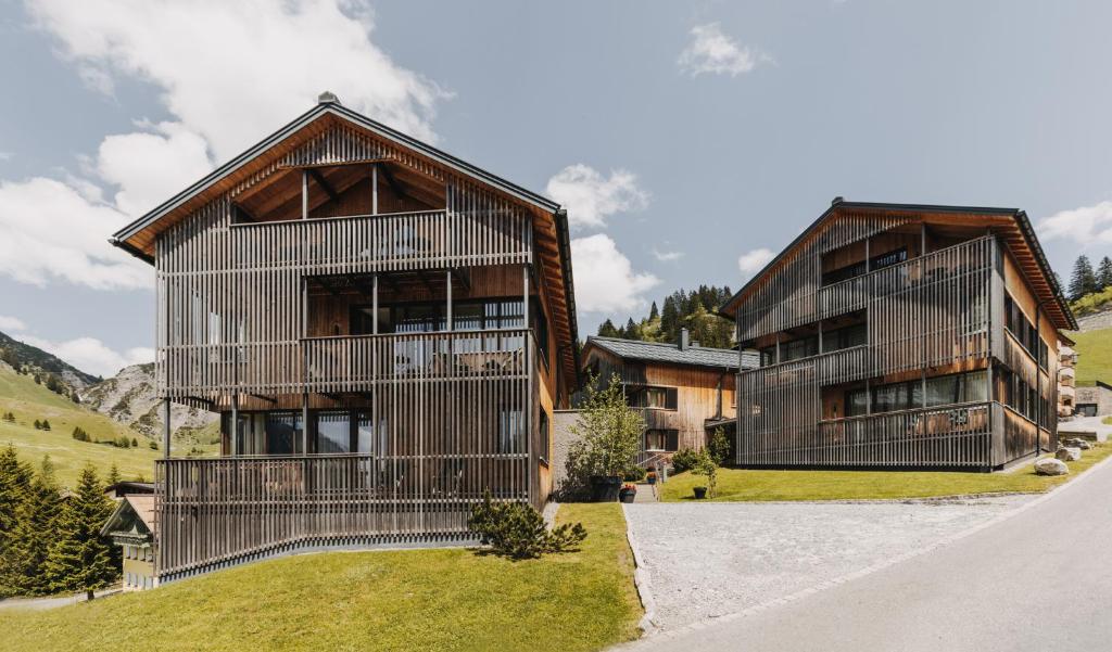 uma grande casa de madeira com uma varanda em Arlberg Lodges em Stuben am Arlberg