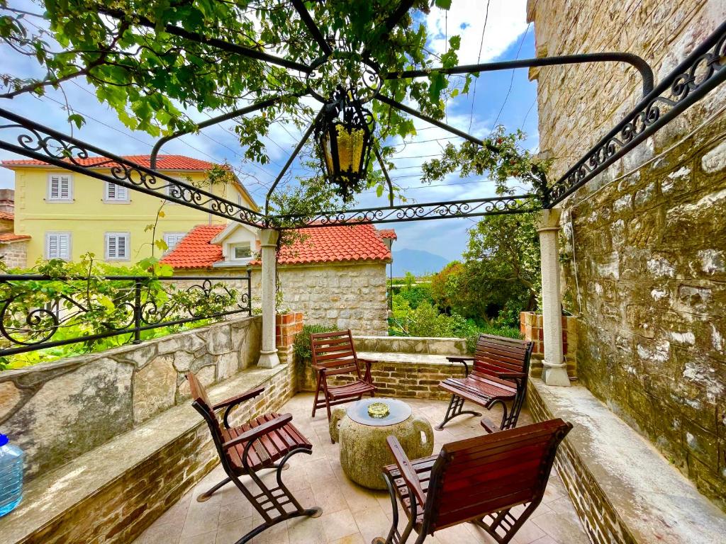 un patio con sillas, una mesa y un edificio en Old town house with private garden en Budva