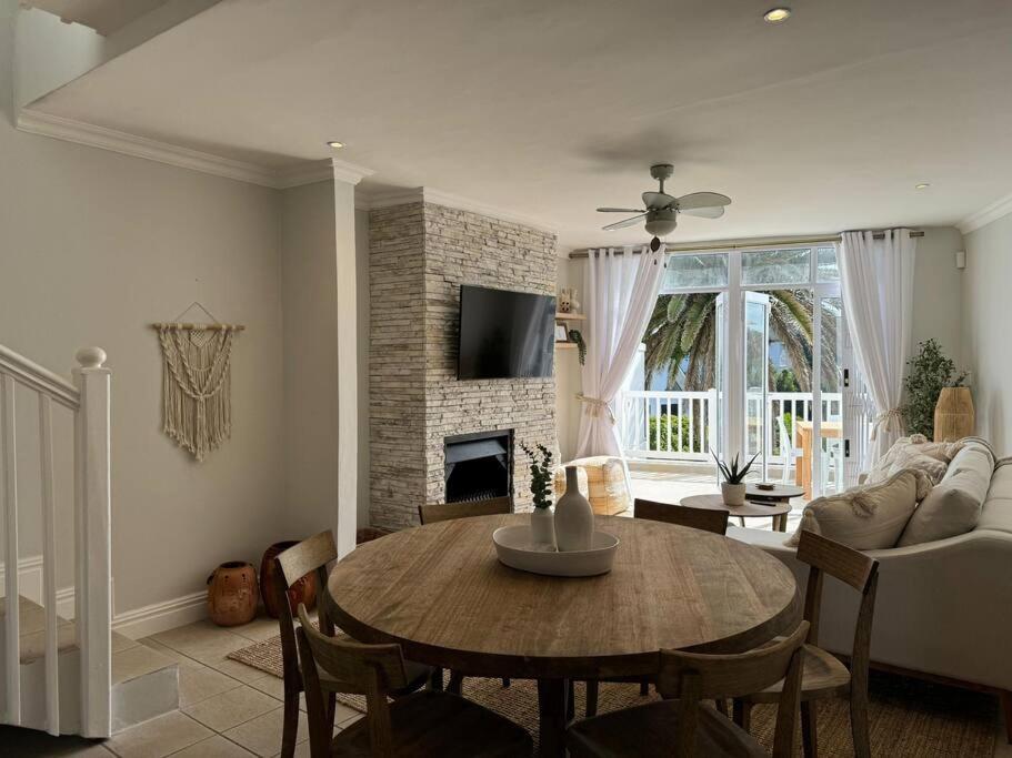 a living room with a table and a fireplace at High tide at no 16 in St Francis Bay