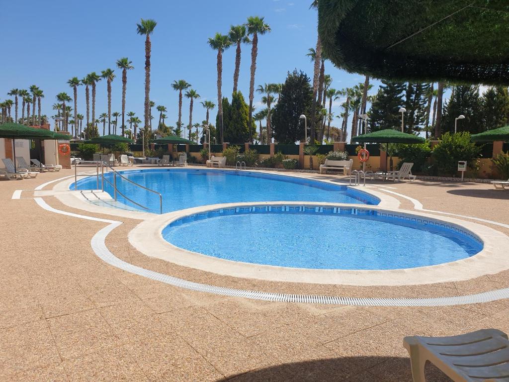 uma grande piscina num resort com palmeiras em Holiday Costa marina 3MED006 em El Borseral