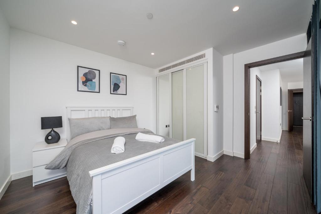 Habitación blanca con cama y espejo en Cosy 1 Bed apartment in Tower Hill, en Londres