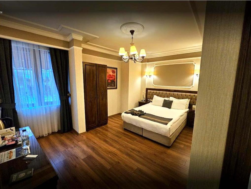 イスタンブールにあるAhmet Efendi Konağıのベッドとシャンデリアが備わるホテルルームです。