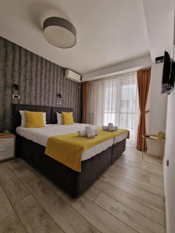 a bedroom with a large bed with yellow pillows at Garni House 46 Plus in Belgrade