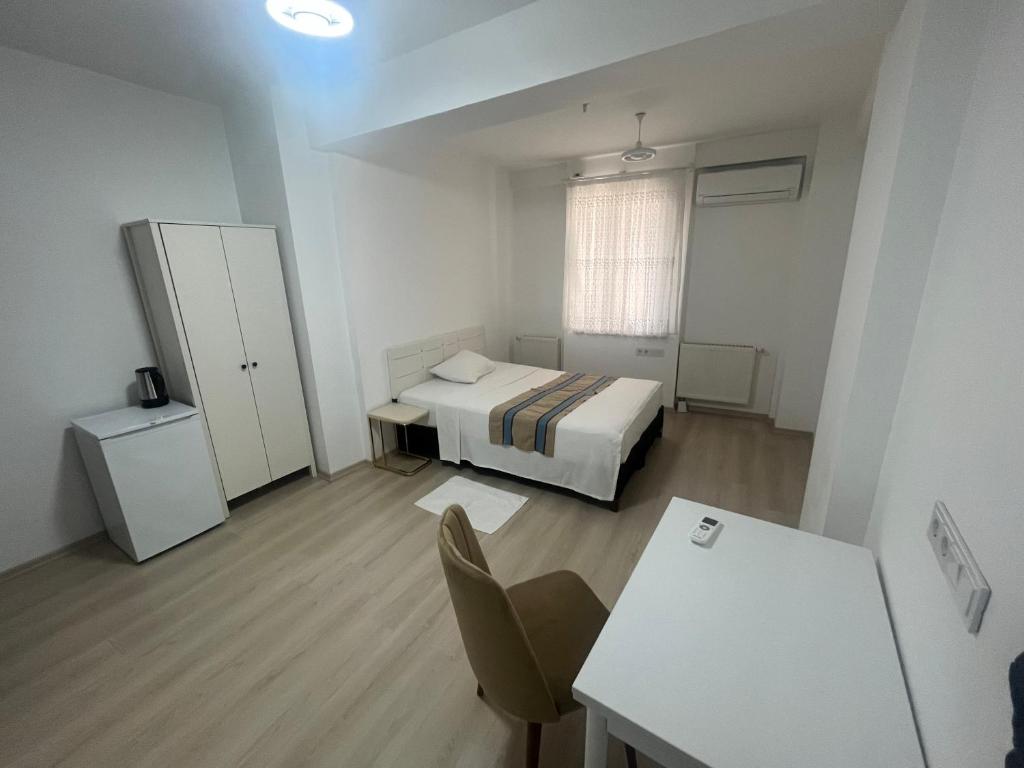 a bedroom with a bed and a desk and a table at Türkmen hotel in Istanbul