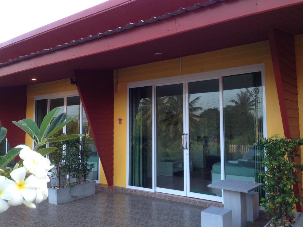 una casa con puertas correderas de cristal y un banco en My Home Resort, en Suratthani