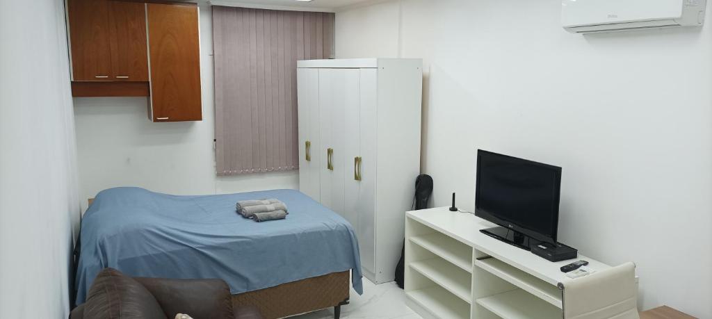 ein kleines Zimmer mit einem Bett und einem Fernseher in der Unterkunft Apto Home Office no Centro/Bela Vista de São Paulo in São Paulo