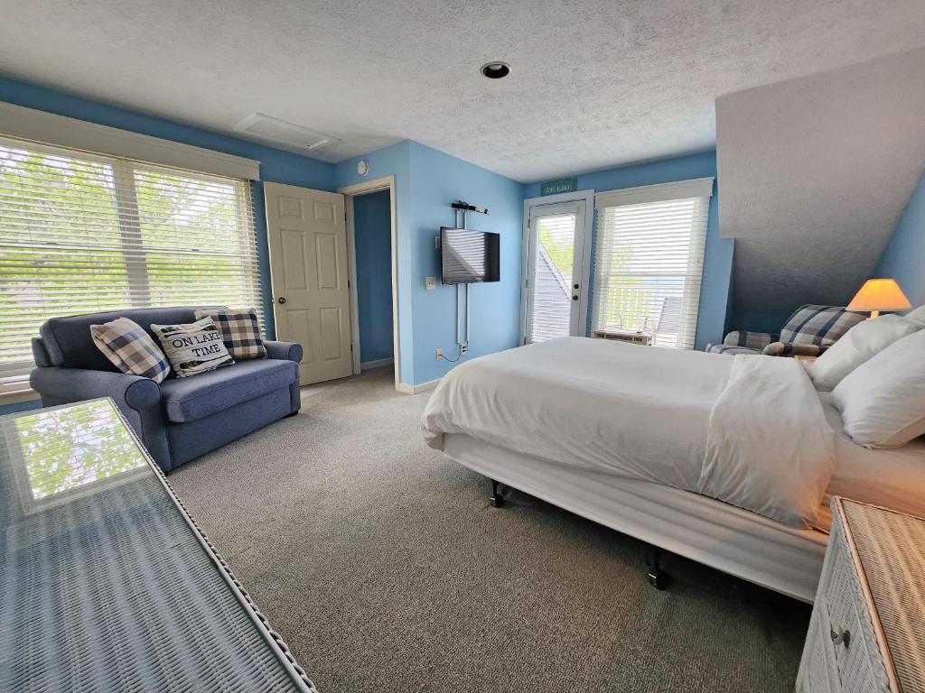 a bedroom with blue walls and a bed and a couch at North Shore Inn TC 301 in Traverse City