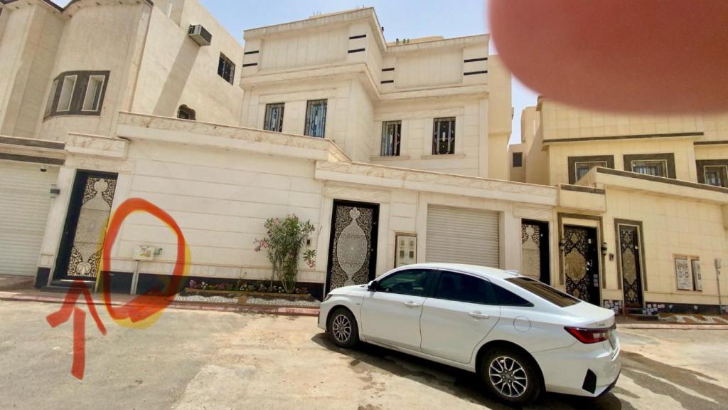 شقة فاخرةبمدخل خاص في الرياض: سيارة بيضاء متوقفة أمام مبنى