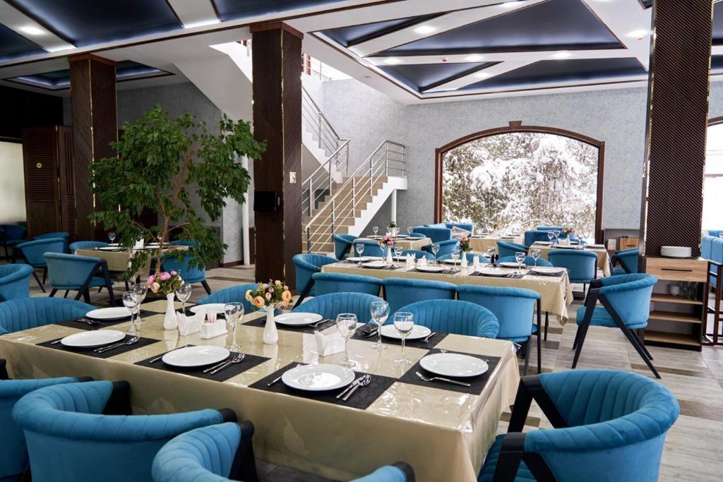 uma sala de jantar com mesas e cadeiras azuis em Ulug`bek Grand Hotel em Samarkand