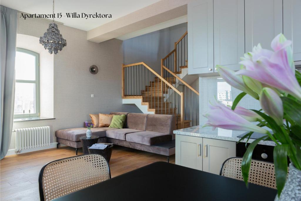 ein Wohnzimmer mit einem Sofa und einer Treppe in der Unterkunft Browar Hevelius Apartments in Danzig
