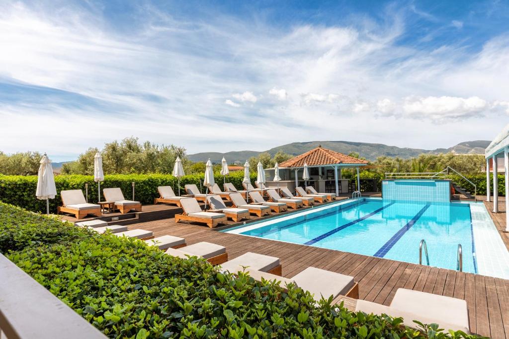 una imagen de una piscina con tumbonas y un complejo en Agrilia Hotel Adults Only, en Laganas