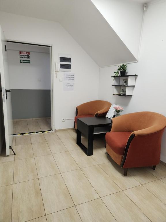 - une salle d'attente avec deux chaises et une table dans l'établissement Hostel Warszawa Ursynów, à Varsovie