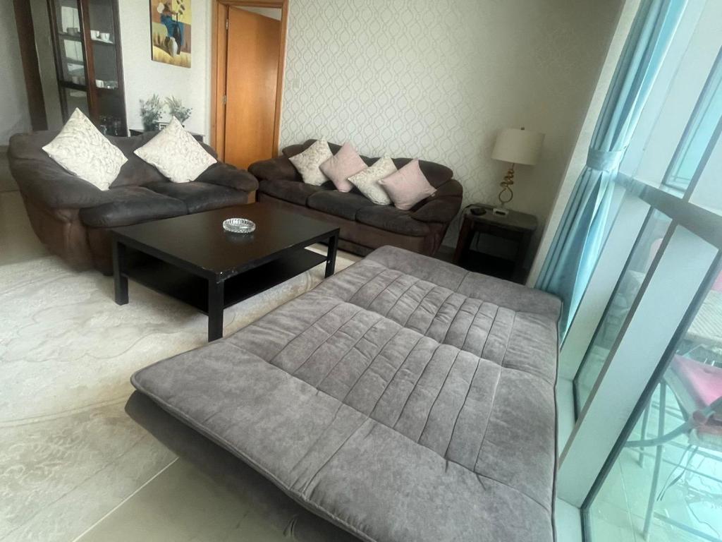 a living room with a couch and a coffee table at Luxury 1BR Uninterrupted Sea View, Fully Equipped in Ras al Khaimah