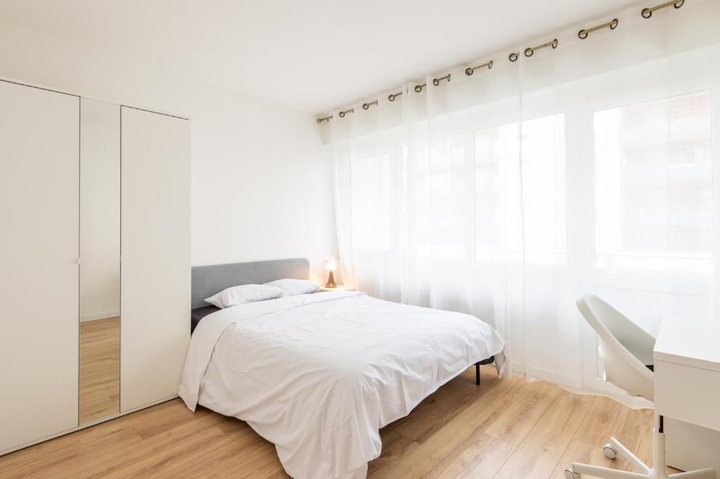 une chambre blanche avec un lit et une fenêtre dans l'établissement M50 Marquer Jolie chambre, à Annemasse