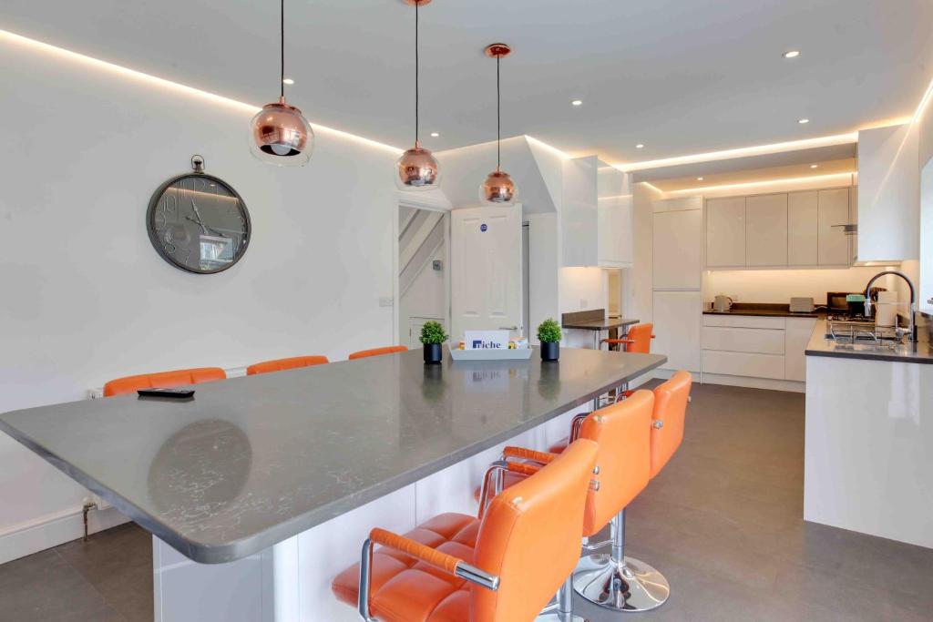 een keuken met een aanrecht en oranje stoelen bij The Burlington at Romford in Romford