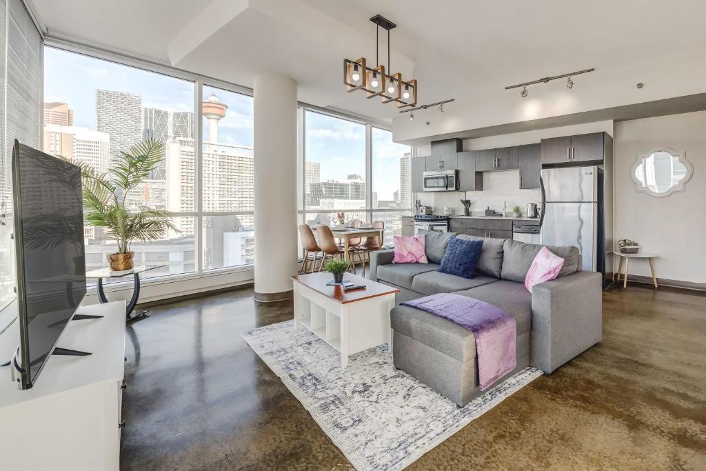 a living room with a couch and a tv at Luxury 2BR Condo - Downtown City Views in Calgary