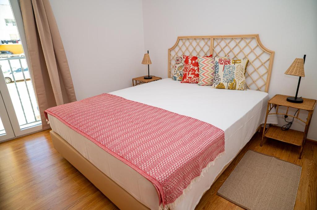 una camera con un letto con una coperta rossa e bianca di TURISALENTEJO - ATIVIDADES TURÍSTICAS, LDA a Redondo