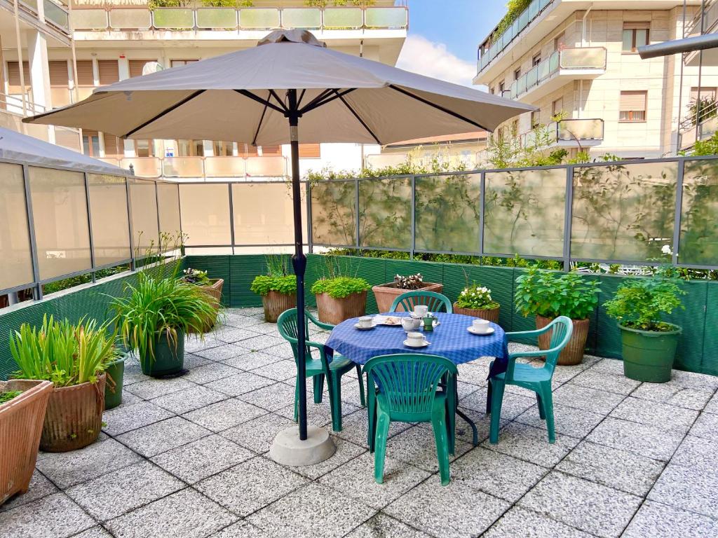 a table and chairs under an umbrella on a patio at Sailor House Arona in Arona