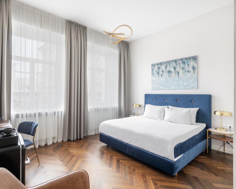 ein Hotelzimmer mit einem Bett und einem Stuhl in der Unterkunft GRAND CROWN in Vilnius