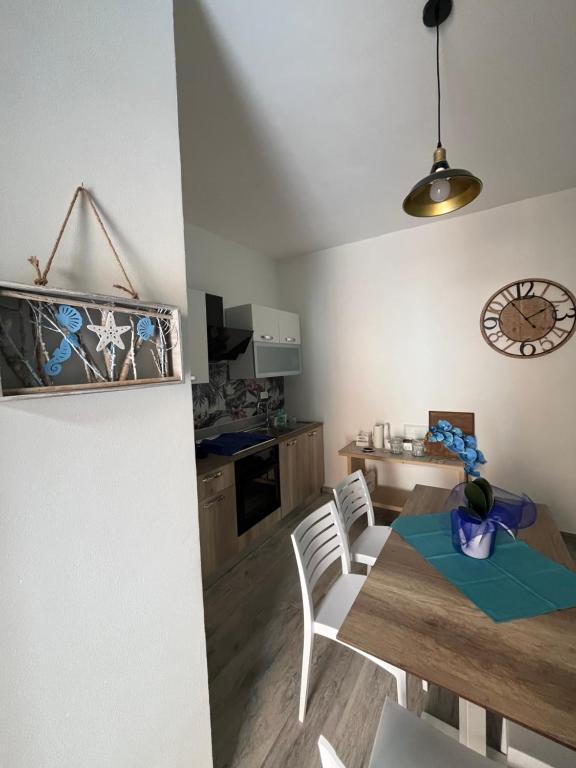 uma cozinha e sala de jantar com mesa e cadeiras em Perla Marina em Realmonte