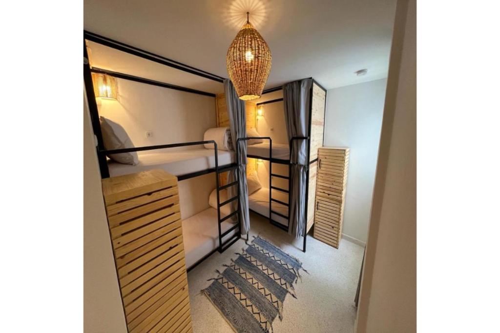 Cette chambre comprend 3 lits superposés et un lustre. dans l'établissement Socco Hostel, à Tanger