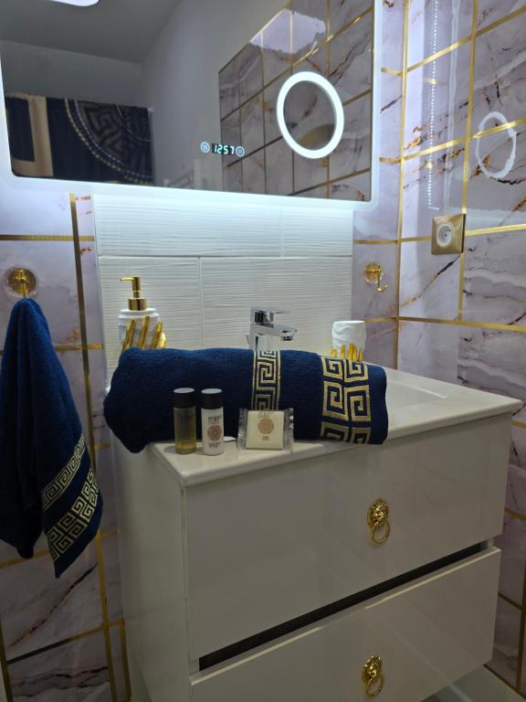 Maison équipée - balnéothérapie - sauna infrarouge - siège massant et pièce secrète : خزانة بيضاء مع الوسائد الزرقاء ومرآة