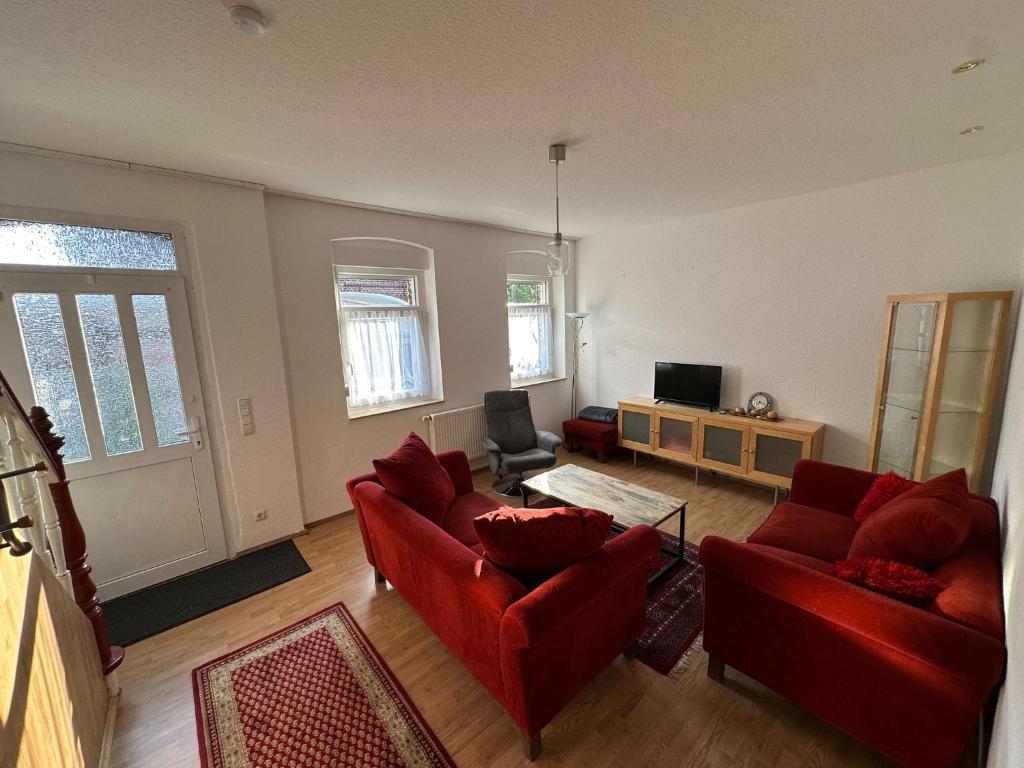 a living room with two red couches and a tv at Idyllisches Zechenhaus, auch geeignet als Monteurenwohnung in Essen