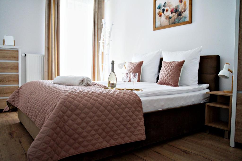 sypialnia z dużym łóżkiem z białą i różową pościelą w obiekcie Magic Apartments - Bulwary 3 w Oświęcimiu