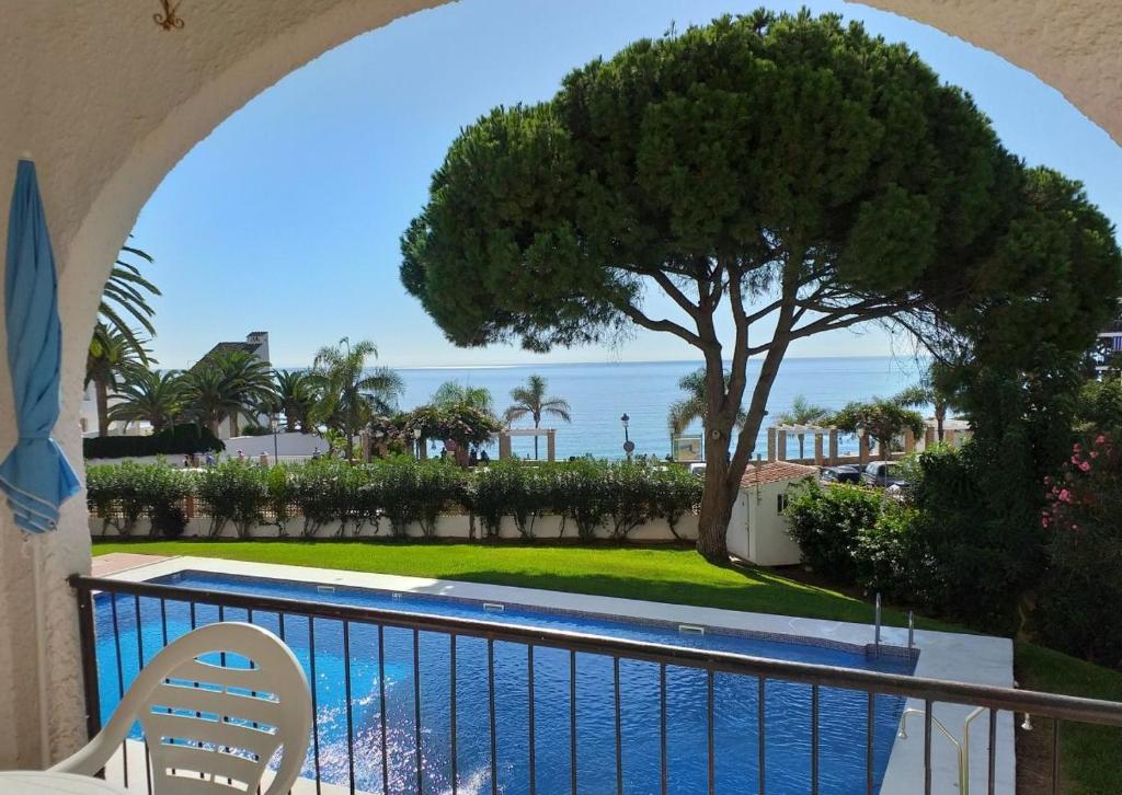 een uitzicht vanaf het balkon van een resort met een boom bij VERDEMAR 16 MENYBER in Nerja