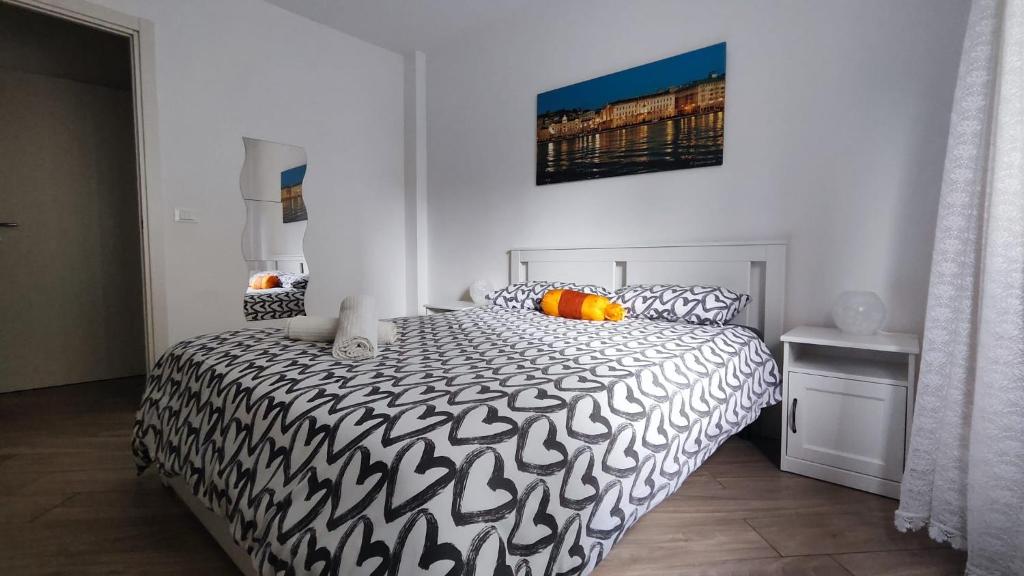 - une chambre avec un lit et une couette noire et blanche dans l'établissement Casa vacanza SERENDIPITY HOME, à Trieste