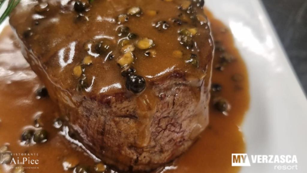 a piece of meat with chocolate sauce on a plate at MyVerzasca Resort Ai piee in Brione