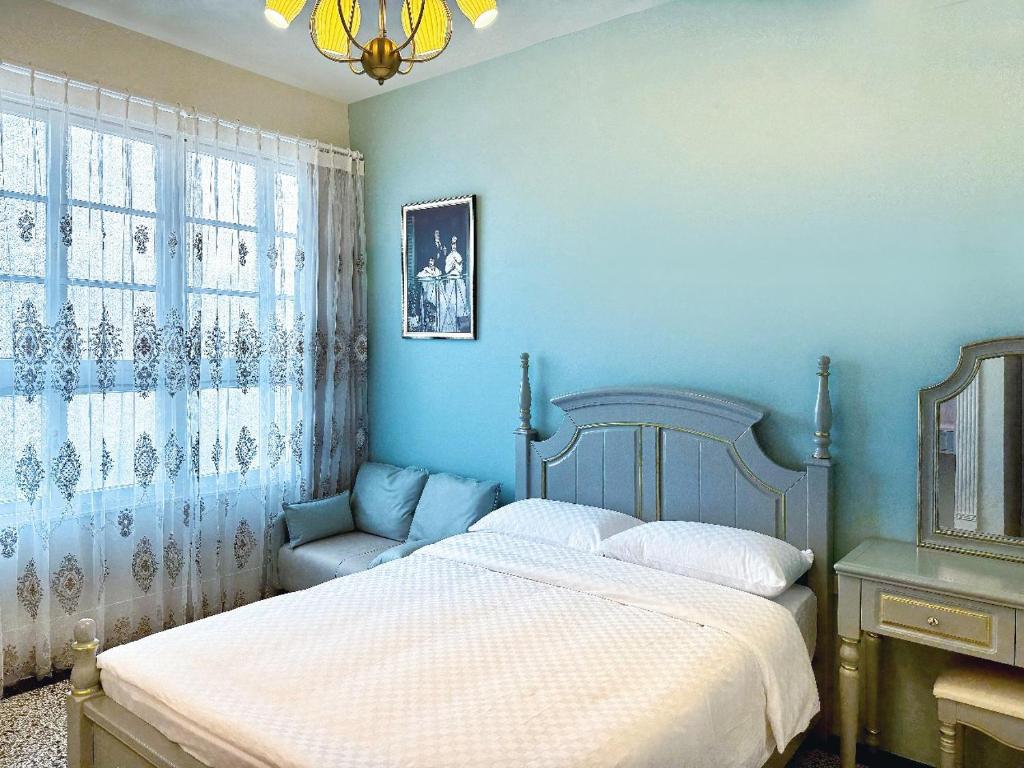 1 dormitorio azul con 1 cama y 1 silla en 朗香洋房 法式老洋房 台南民宿684編號 en Anping