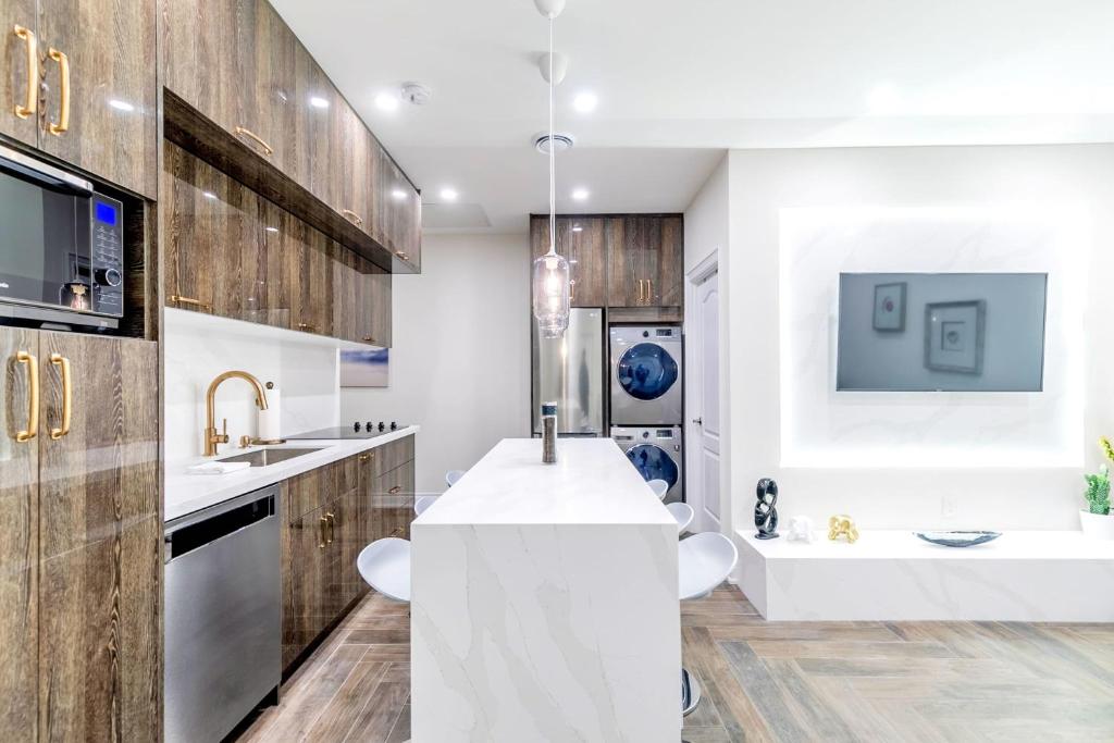 uma cozinha com armários de madeira e um balcão branco em Luxury 2BR Unit - Heart of the Chinatown em Toronto