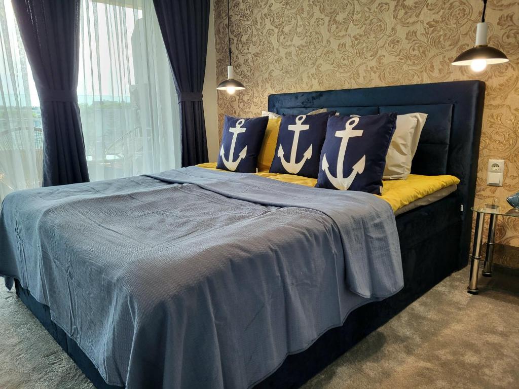 Una cama azul con almohadas en el dormitorio en Sea view luxury appartment-parking, en Varna