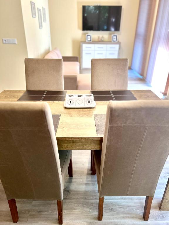 a dining room table with two chairs and a television at Апартамент Франческа in Varna City