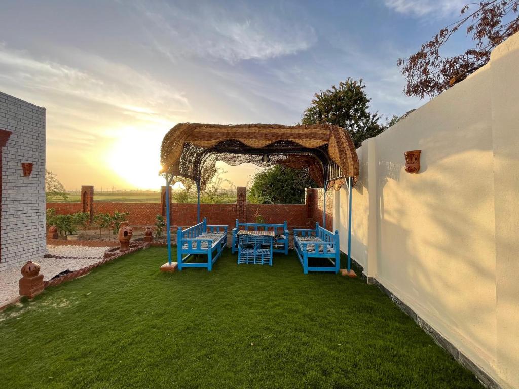 een buitenterras met blauwe tafels en een prieel bij Julia House in Luxor