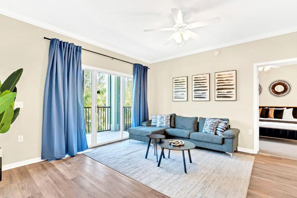 een woonkamer met een bank en een tafel bij 2BR Condo - Pool Hot Tub & Games - Near Disney in Orlando