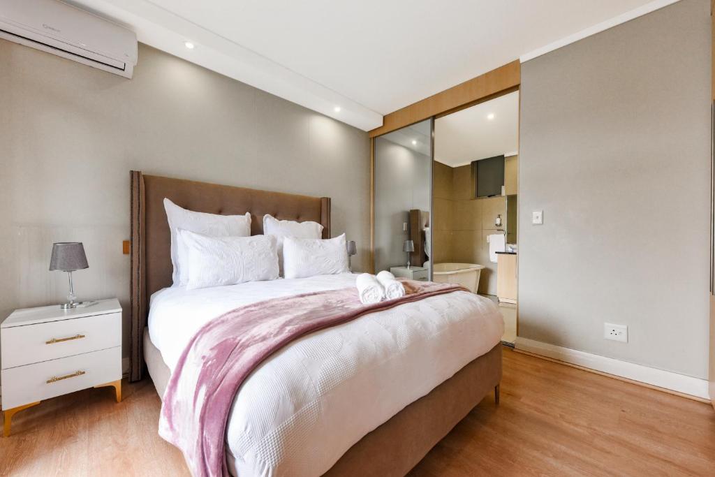a bedroom with a large bed and a large mirror at Hydro Park Residences in Sandton WITH GENERATOR in Johannesburg