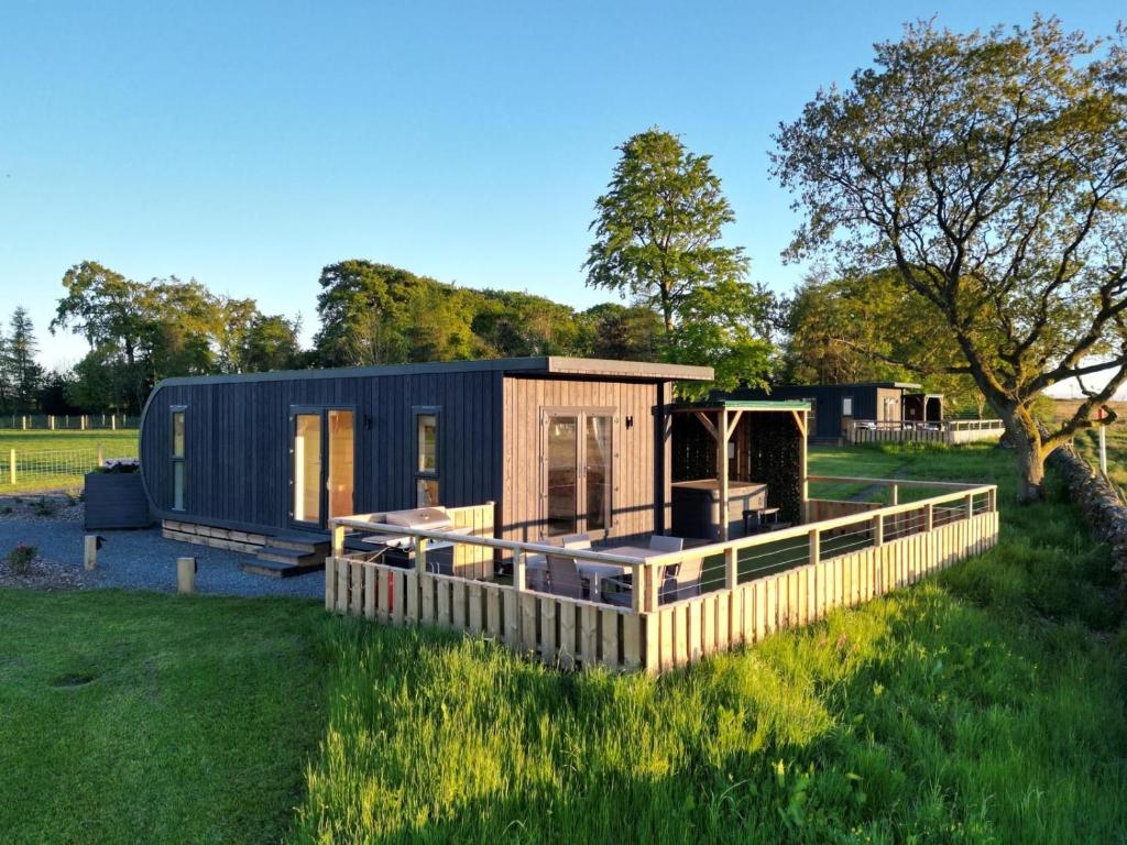 a tiny house in a field with a fence at Green Law - Dog Friendly in Penicuik