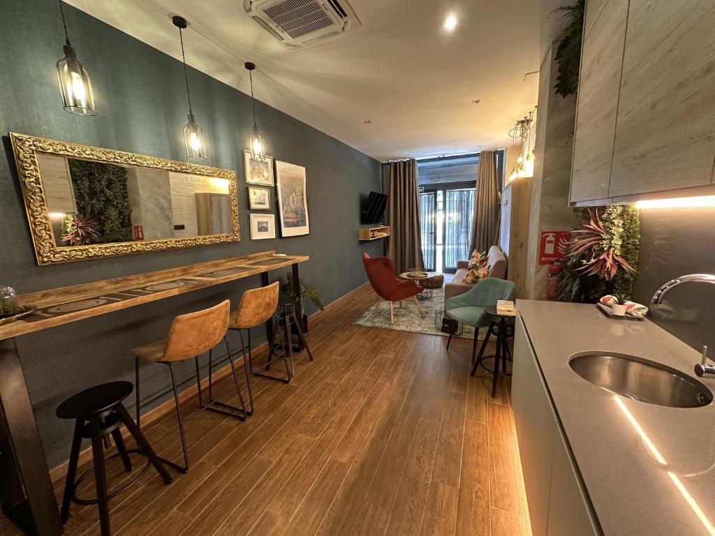 a kitchen with a bar and a living room at Magnifica vivienda a estrenar junto a Plaza España in Valencia