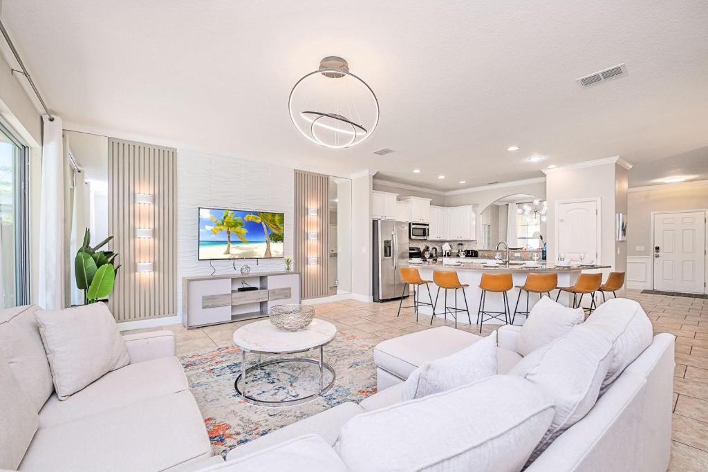 a living room with white furniture and a kitchen at Solterra Resort Home - Waterslide and Lazy River in Davenport