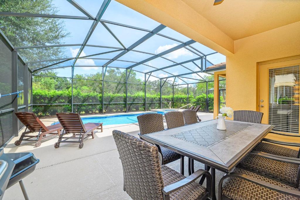a patio with a table and chairs and a pool at Solterra Resort Home - Waterslide and Lazy River in Davenport