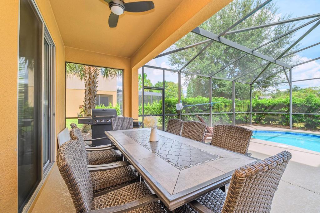a patio with a table and chairs and a pool at Solterra Resort Home - Waterslide and Lazy River in Davenport